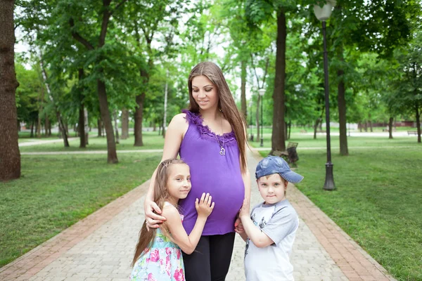 Donna incinta con bambini nel parco — Foto Stock