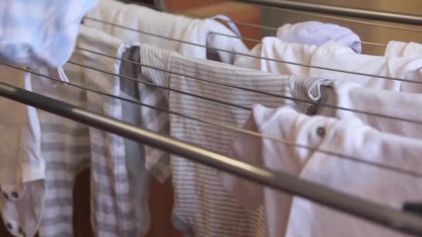 Les mains des femmes retirent les vêtements de bébé du sèche-linge. — Video