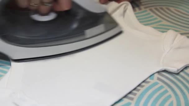 Mano femenina planchando ropa de bebé de cerca. — Vídeos de Stock