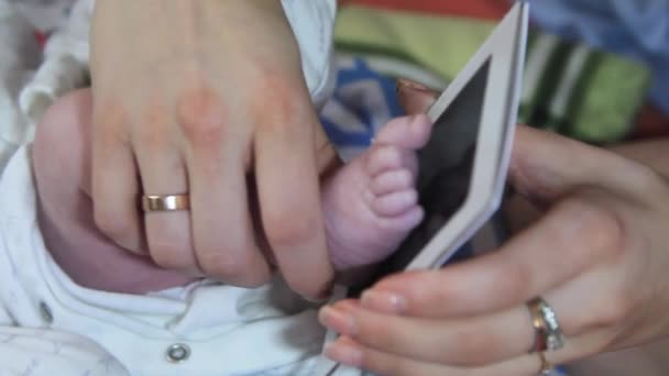 A mãe faz uma impressão, uma impressão de um pé de crianças em papel fotográfico — Vídeo de Stock