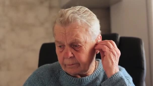Elderly woman grandmother putting on headphones close-up. — Stock Video