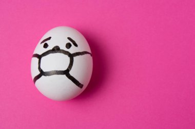 Yüzünde maske olan bir yumurta. Fotokopi alanı olan pembe bir arka plan. İlaç konsepti Covid 19 'u karantinaya al.