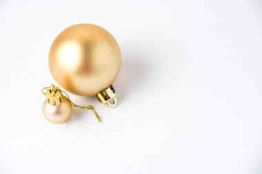 Noel dekoru Beyaz arka planda iki parlak altın top.