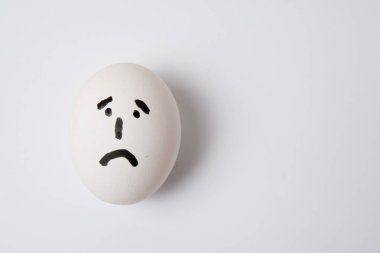 Üzgün ve hayal kırıklığına uğramış bir yumurta, beyaz arkaplan kopyalama boşluğunda.