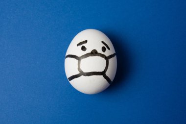 Yüzünde maske olan bir yumurta. Fotokopi alanı olan mavi bir arka plan. İlaç konsepti Covid 19 'u karantinaya al