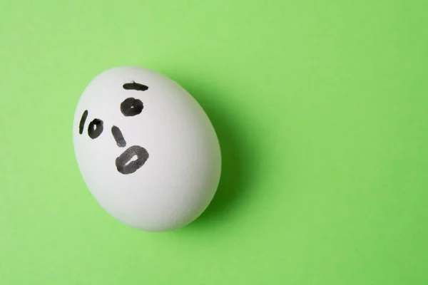 Huevo Con Una Cara Sorprendida Sobre Fondo Verde Con Espacio — Foto de Stock