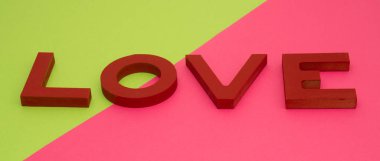 Sevgililer günü, kırmızı ahşap harfler yeşil-pembe arka planda aşk, afiş biçimi.