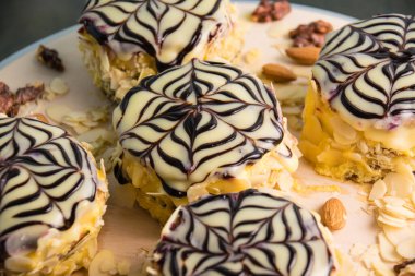 Kremalı lezzetli kekler, açık tahta üzerinde siyah beyaz çikolata yakın plan, tatil konsepti.