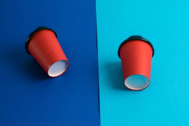 Parlak arka planda plastik kapaklı kırmızı kağıt bardaklar kopyalama alanı.