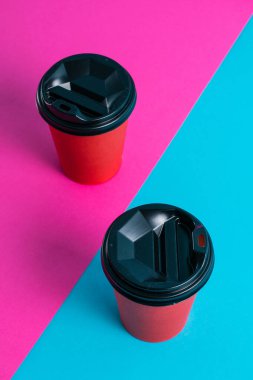 Parlak arka planda plastik kapaklı kırmızı kağıt bardaklar kopyalama alanı.