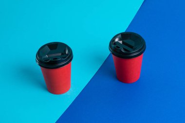 Parlak arka planda plastik kapaklı kırmızı kağıt bardaklar kopyalama alanı.