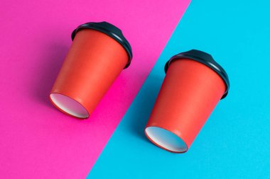 Parlak arka planda plastik kapaklı kırmızı kağıt bardaklar kopyalama alanı.