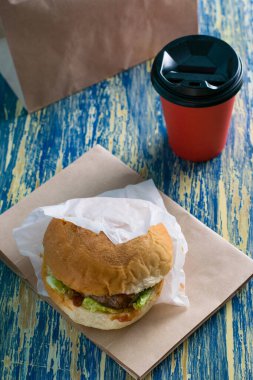 Sığır pirzolası, sos, salata ve kahveyi kağıt bardakta üst üste, dikey formatta görmek için. Yemek teslimatı kavramı, karantina döneminde restoran işletmesi..