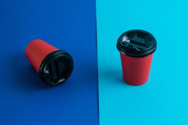 Parlak arka planda plastik kapaklı kırmızı kağıt bardaklar kopyalama alanı.