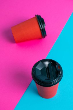 Parlak arka planda plastik kapaklı kırmızı kağıt bardaklar kopyalama alanı.