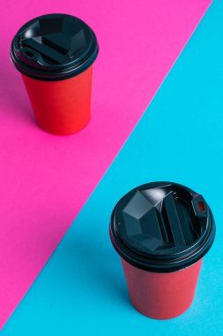 Parlak arka planda plastik kapaklı kırmızı kağıt bardaklar kopyalama alanı.