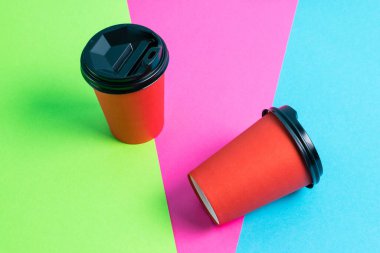 Parlak arka planda plastik kapaklı kırmızı kağıt bardaklar kopyalama alanı.