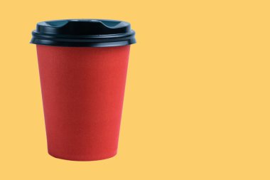 Açık terasotta zemin üzerinde plastik kapaklı kırmızı kağıt bardak, yan görünüm, sağdan boşluğu kopyala.