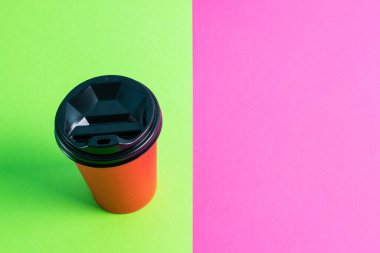 Renkli arkaplan görünümlü plastik kapaklı kırmızı kağıt bardak.