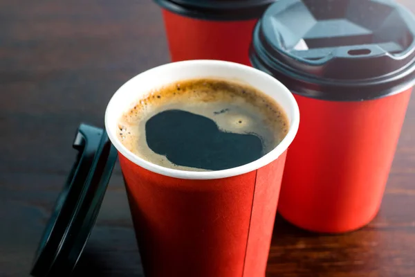 Takeaway coffee in paper cups on a wooden table. The concept of cafes and restaurants during the covid 19 quarantine period, lunch break