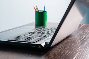 Ahşap bir masada yakın plan dizüstü bilgisayar. Bilgisayarlı ofis masası, insan yok..