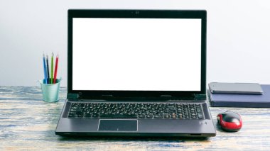 Dizüstü bilgisayarı, akıllı telefonu, defteri, kalemleri ve bilgisayar faresi olan işyeri