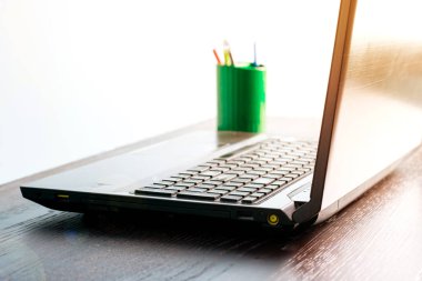 Koyu ahşap bir masada dizüstü bilgisayar, kopyalama alanı. Uzaktan çalışma ya da çalışma konsepti, karantina covid 19