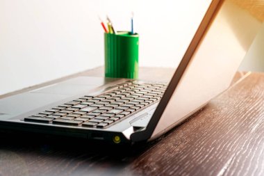 Koyu ahşap bir masada dizüstü bilgisayar, kopyalama alanı. Uzaktan çalışma ya da çalışma konsepti, karantina covid 19