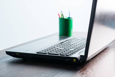 Ahşap bir masada yakın plan dizüstü bilgisayar. Bilgisayarlı ofis masası, insan yok..