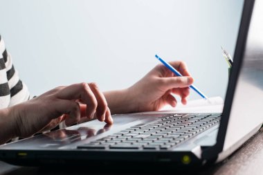 İnternette okumak, çalışmak, internette bilgi aramak için bir kişi dizüstü bilgisayar kullanır. Eller ve dizüstü bilgisayar klavyeyi kapat.