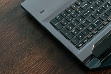 Koyu ahşap masadaki dizüstü bilgisayarı kapat, boşluğu kopyala.