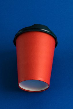 Koyu mavi arkaplan üzerinde plastik kapaklı kağıt bardak kopyalama alanı.