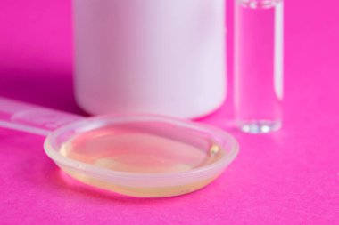 İlaçlı ampul, tıbbi karışım ve pembe arka planda beyaz bir kavanoz hap..