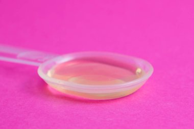 Pembe arka plan fotokopi alanında tıbbi ilaçlar. Şeffaf plastik kaşıkta ilaç.