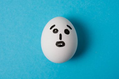 Şaşırmış bir suratı olan yumurta. Mavi arkaplanda izole et