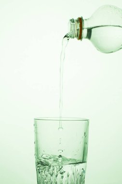 Bir adam şeffaf plastik şişeden bardağa su döker.