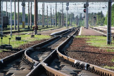 Güneşli bir akşamda tren istasyonu, uzak mesafelere giden raylar. Seyahat ve iş konsepti
