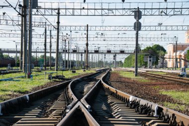Güneşli bir akşamda tren istasyonu, uzak mesafelere giden raylar. Seyahat ve iş konsepti
