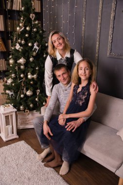 Mutlu güzel bir aile Noel 'de bir ev ya da dairenin içinde zarif bir Noel ağacının yanında..