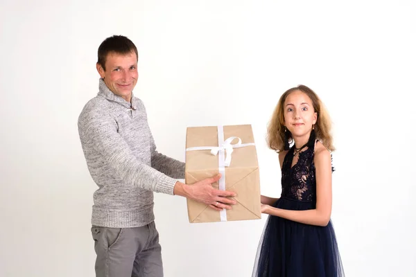 Dad gives a big gift to his daughter on a white background.