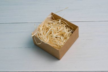 Tahta zemin üzerinde ahşap doldurucu ve kopya alanı olan el işi hediye kutusu.