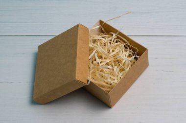 Tahta zemin üzerinde ahşap doldurucu ve kopya alanı olan el işi hediye kutusu.