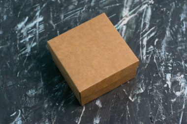 Brown craft box on a dark gray background. Gift selection concept.