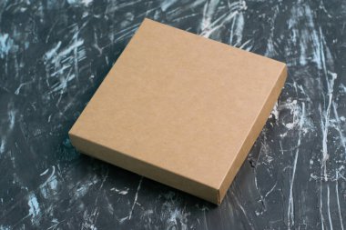 Brown craft box on a dark gray background. Gift selection concept.