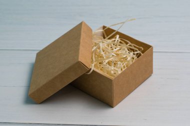 Tahta zemin üzerinde ahşap doldurucu ve kopya alanı olan el işi hediye kutusu.