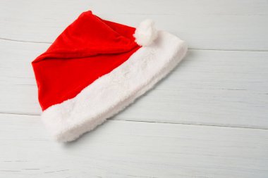 Noel Baba şapkası açık ahşap bir masada. Kopya alanını kapat..