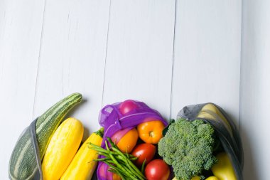 Sıfır atık, gıda alışverişi, sebze ve meyve için eko torbaları. Sebzeler, brokoli, kuşkonmaz fasulyesi, kabak, biber ve domatesler çevre dostu düz poşetlerde, kopyalama alanı.