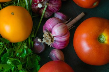 Bir sürü sebze: sarımsak, kişniş, maydanoz ve domates..
