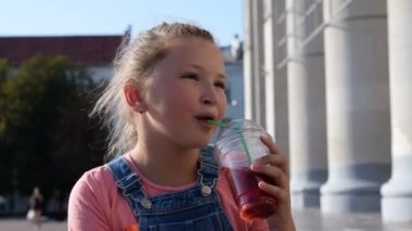 Şehir merkezinde bir yaz akşamı limonata içen genç bir kız.