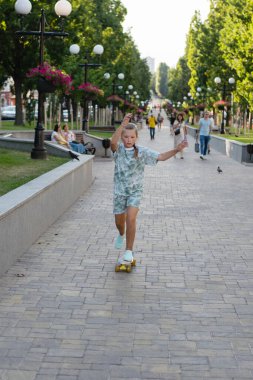 Parktaki şehir merkezinde kaykaylı bir genç. Güzel bir kız bir yaz akşamında kaykaya biniyor.